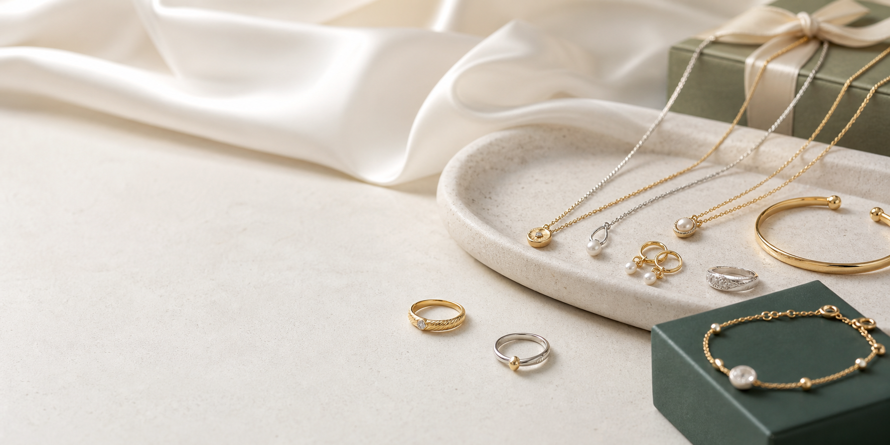 Gold and silver jewelry arranged on silk and stone trays
